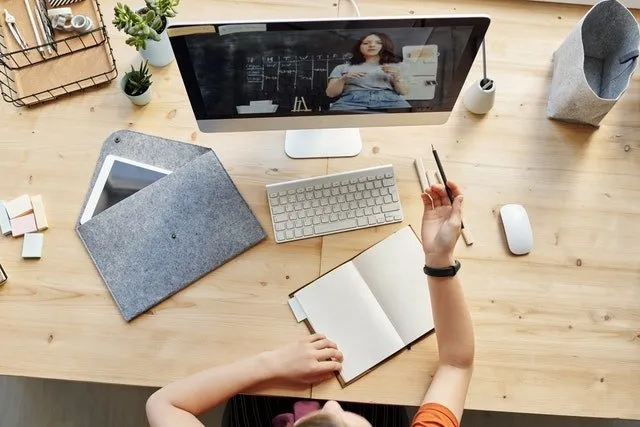 promoted-pins-course woman taking notes while watching online video